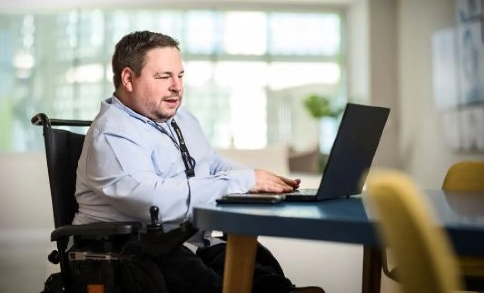 Persona en silla de ruedas trabajando con su ordenador.